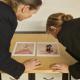 Photo of Professor Catriona Seth and Dr Marie-Eve Celio studying details of Liotard's portraits