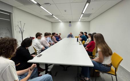 Students sitting in a teaching room facing away from camera with guest speaker.