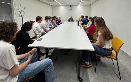 Students sitting in a teaching room facing away from camera with guest speaker.