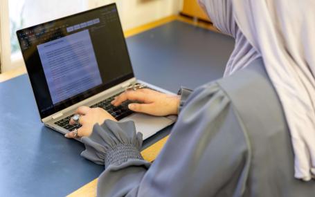A student typing on their laptop