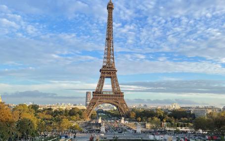 A picture of the Eiffel Tower from afar with a blue sky background