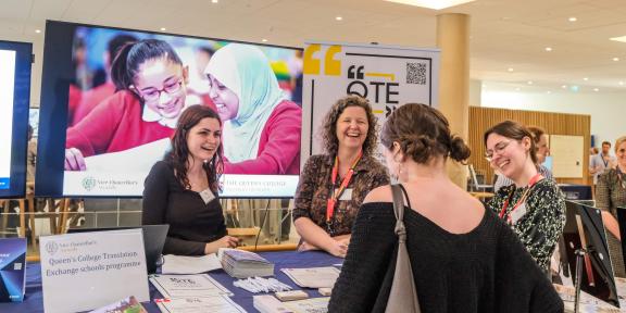 Dr Charlotte Ryland, Dr Elly Walters, and a student ambassador talking to someone at their stall at the Vice Chancellor's awards.