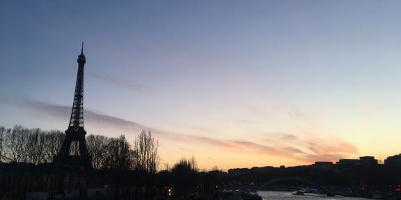 A picture of the Seine in Paris at sunset with a silhouette of the Eiffel Tower on the left-hand side