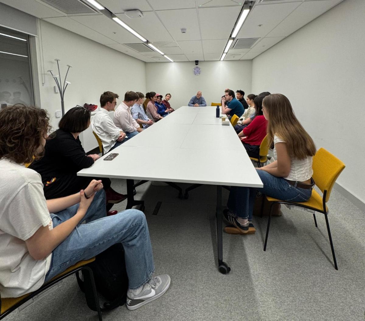 Students sitting in a teaching room facing away from camera with guest speaker.