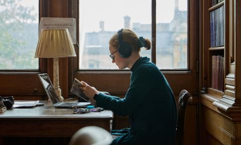 Young woman working in a library by a window