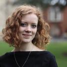 Image of a woman with red hair against a grassy background