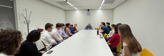 Students sitting in a teaching room facing away from camera with guest speaker.