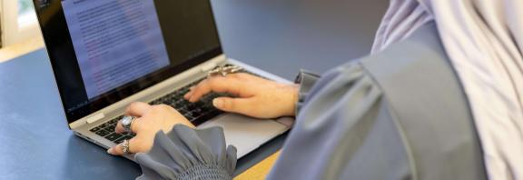 A student typing on their laptop